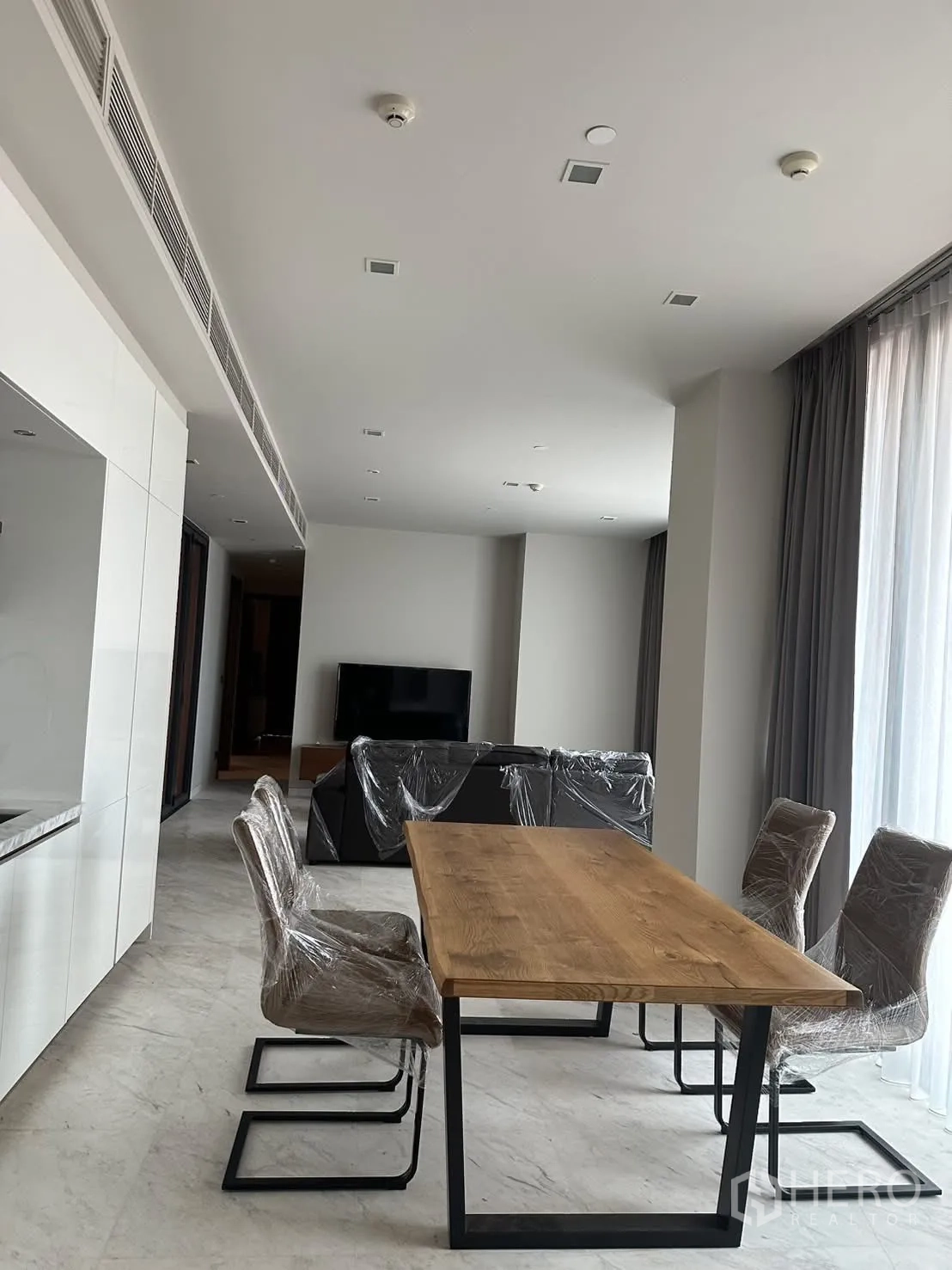คอนโด for rent or sale in Watthana, Bangkok - พื้นที่รับประทานอาหารโต๊ะไม้ เก้าอี้บุนุ่ม 4 ตัว และหน้าต่างบานใหญ่.