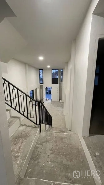 Townhouse for sale in Prawet, Bangkok - Corridor beside the staircase leading to a bright living space.