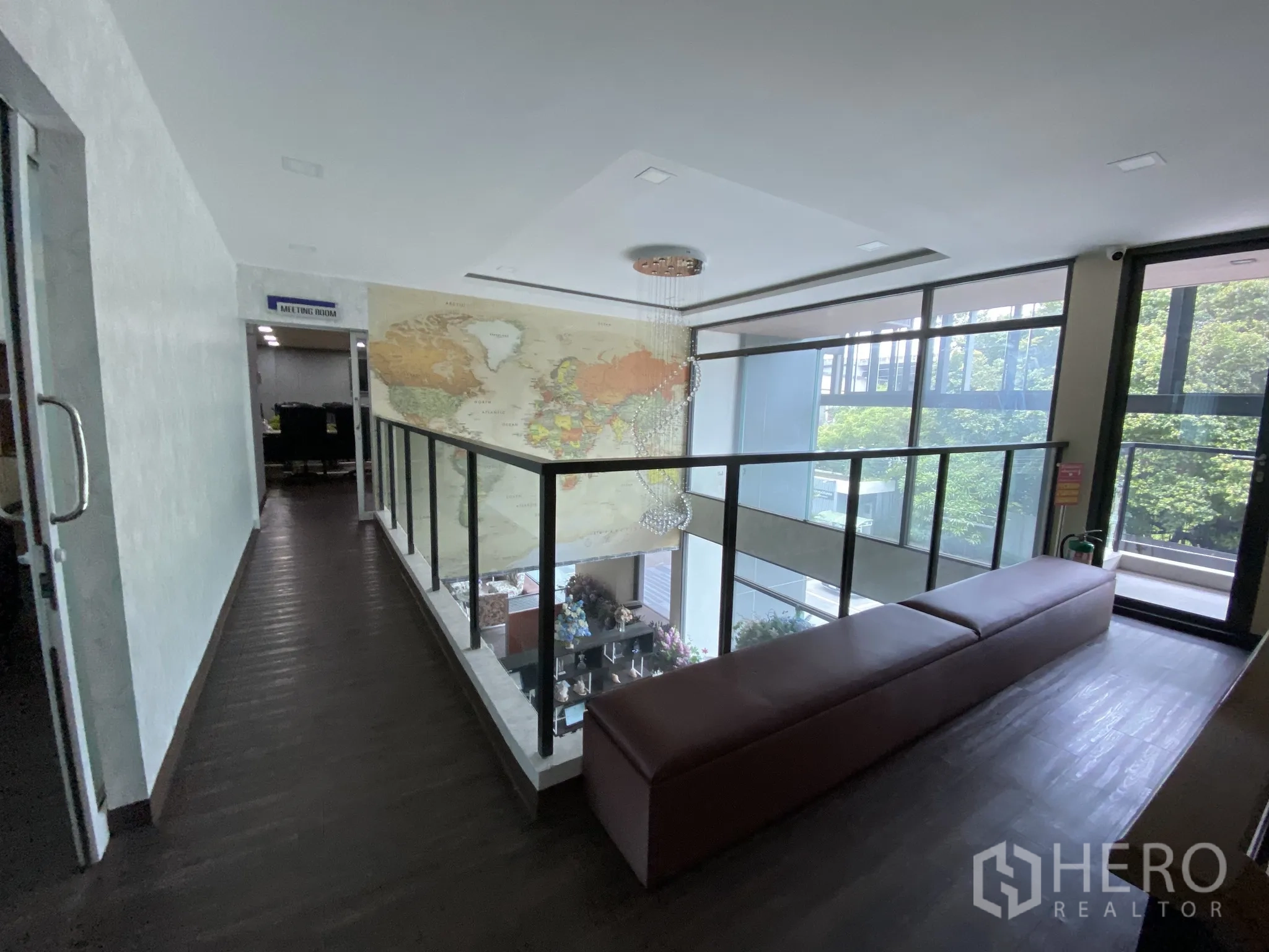 Home Office for rent or sale in Bang Phli, Samut Prakan - Mezzanine walkway with glass railing overlooking an atrium and world map mural.