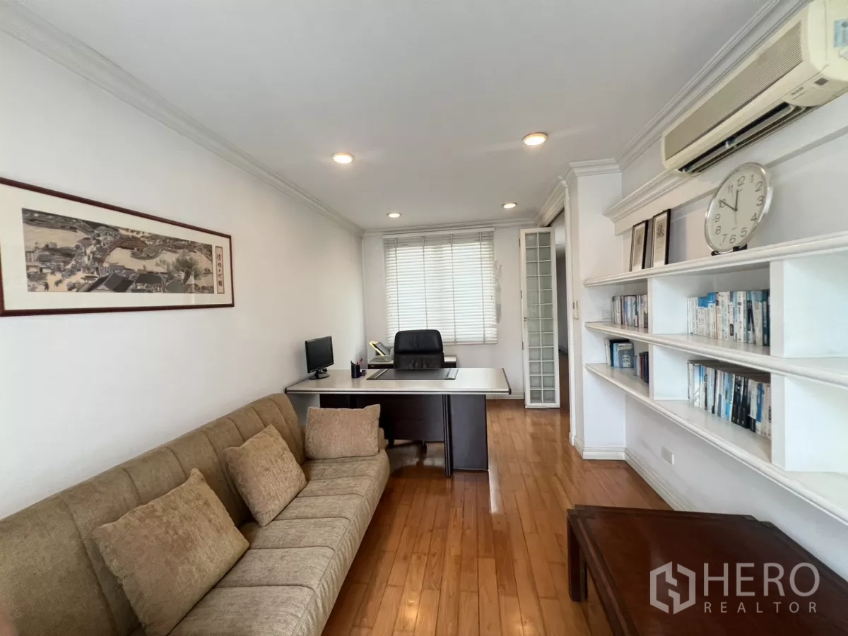 Townhouse for sale in Watthana, Bangkok - Alternate view of home office showing shelving, desk and sofa.