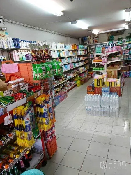 零售空间 出租在Bang Na, Bangkok - 紧凑型店铺空间，产品架与瓶装水展示，荧光灯照明，动线清晰易选购。