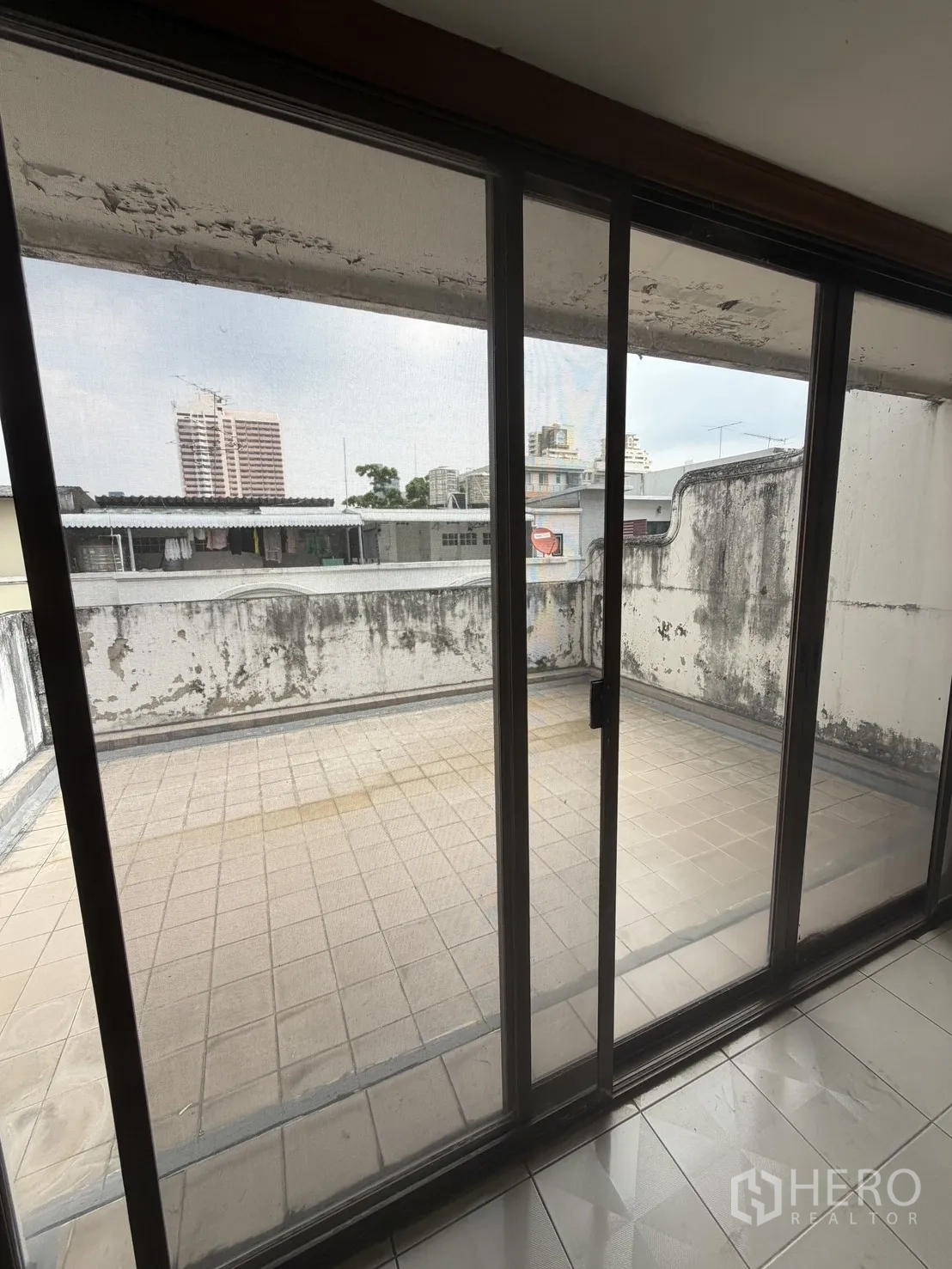 โฮมออฟฟิศ for rent in Watthana, Bangkok - เทอเรซปูกระเบื้องขนาดใหญ่ มองผ่านประตูกระจกบานเลื่อน เห็นวิวเมือง