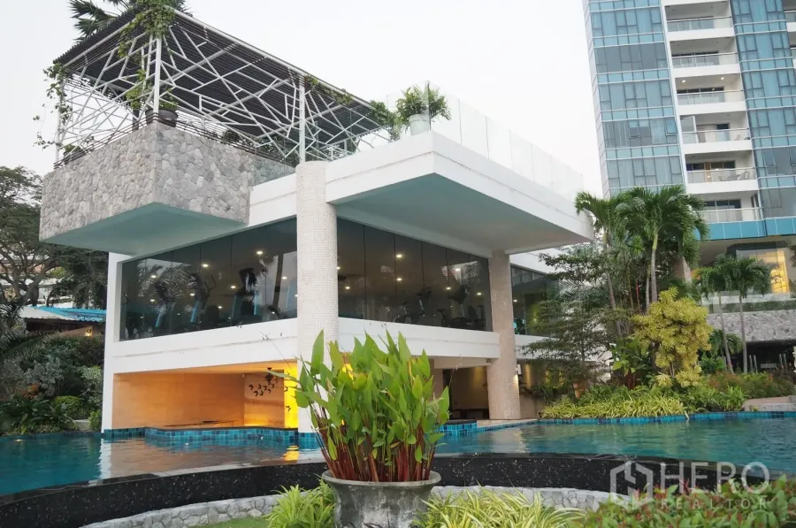 Condominium for rent in Bang Lamung, Chon Buri - Beachfront condominium facilities with a glass-walled gym above an infinity pool and lush gardens in Pattaya.