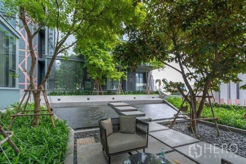 公寓 出租在Watthana, Bangkok - 景观庭院配水景、绿植与户外休闲座椅。