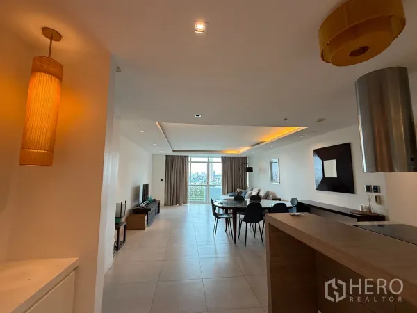 公寓 出租在Phaya Thai, Bangkok - 从厨房望向餐厅与阳台，暖色灯带与城市景观。