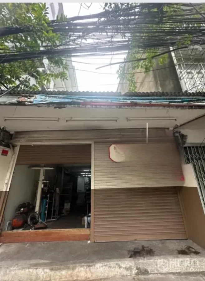 พื้นที่ขายปลีก ให้เช่าในWatthana, Bangkok - หน้าร้านชั้นล่างพร้อมประตูม้วนโลหะและทางเท้า ย่านพระโขนง