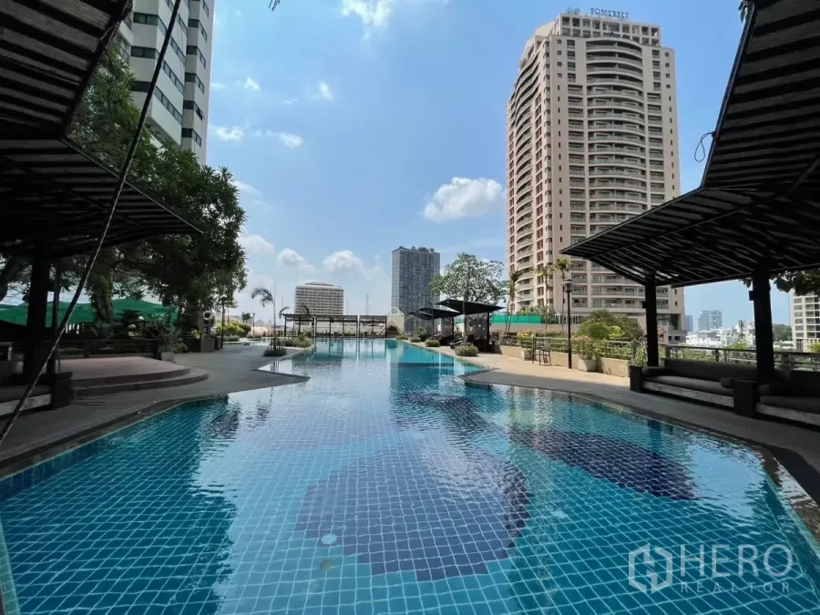 Condominium for rent in Sathon, Bangkok - Resort-style outdoor swimming pool with shaded cabanas and the Sathon city skyline.