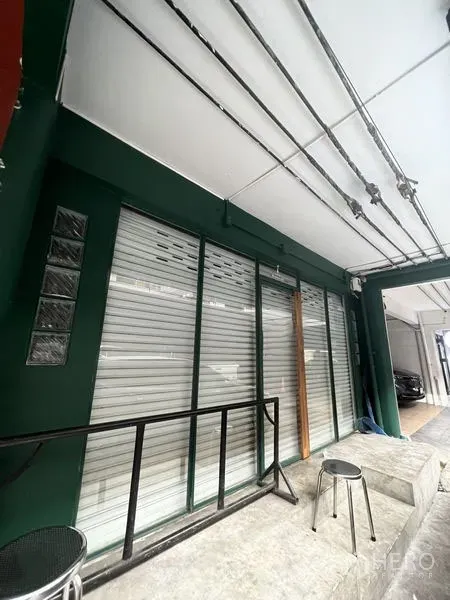 店屋 出租在Khlong Toei, Bangkok - Ekkamai店屋一层外立面，卷帘门与雨棚，前方有小坐凳。