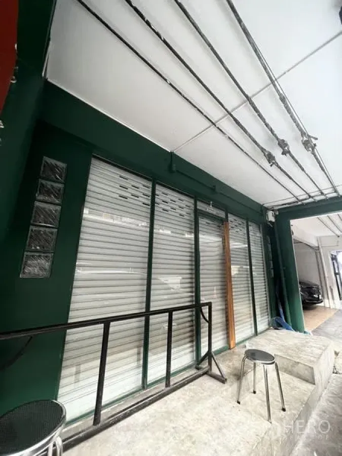 店屋 出租在Khlong Toei, Bangkok - Ekkamai店屋一层外立面，卷帘门与雨棚，前方有小坐凳。