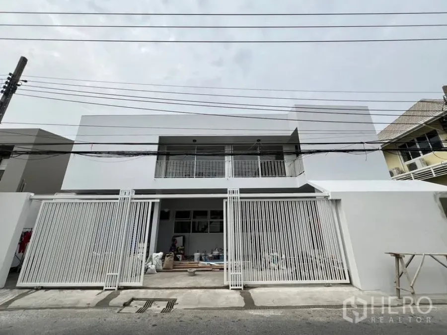 带办公室的家 出租在Huai Khwang, Bangkok - 现代白色两层家用办公楼外观，带金属推拉大门，临安静小巷。