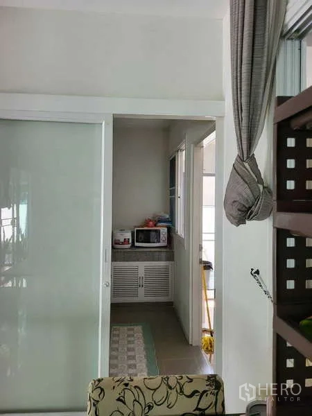 独立式住宅 出租在Lat Krabang, Bangkok - 紧凑型备餐区，带推拉门、微波炉和收纳柜。