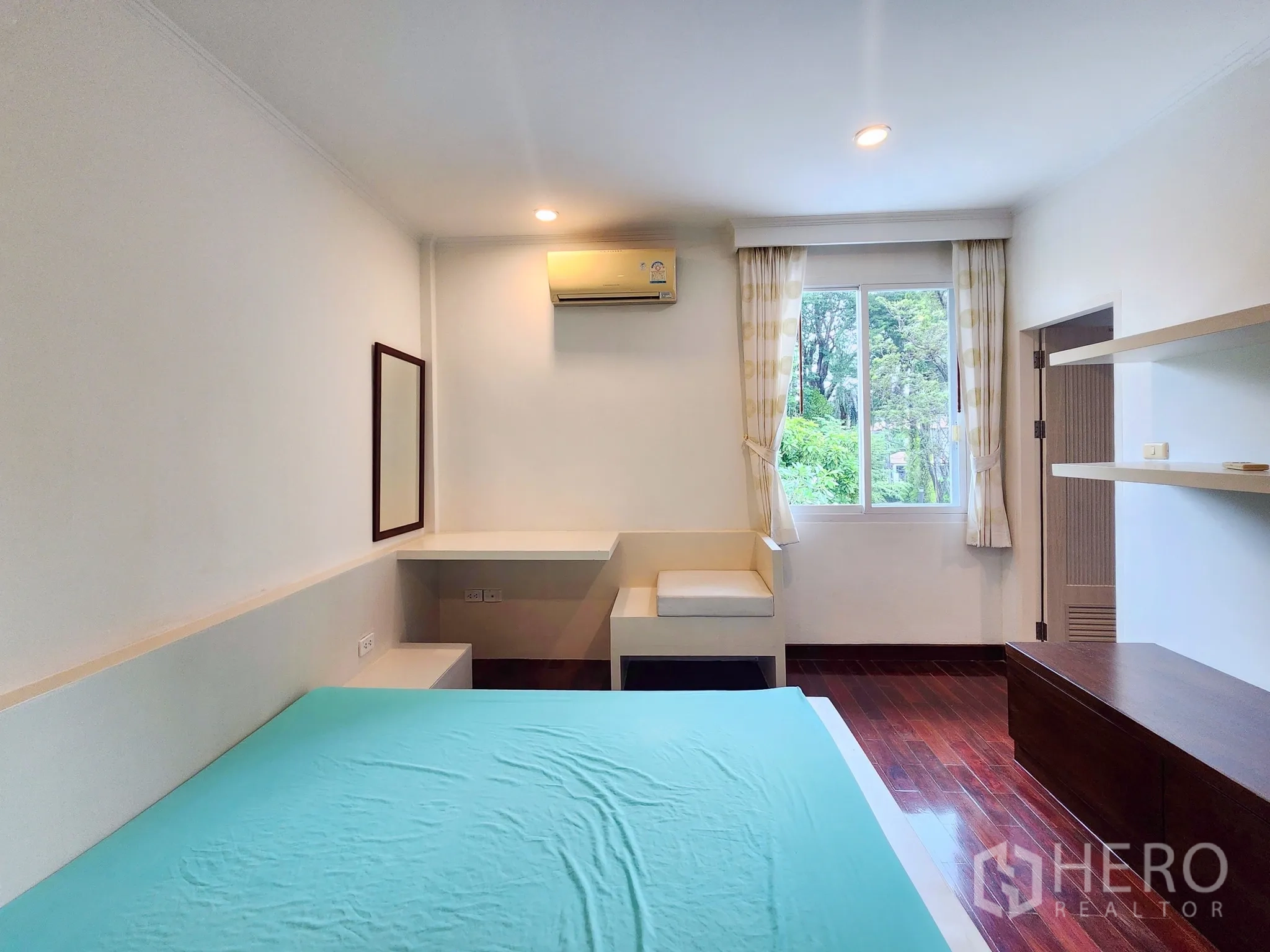 Detached House for rent in Bang Kapi, Bangkok - Secondary bedroom with built-in shelving, storage and wood floors.