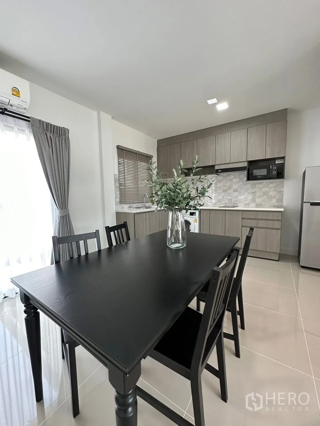 联排别墅 for rent in Bang Phli, Samut Prakan - 餐厅配黑色餐桌和四把椅子，毗邻厨房。