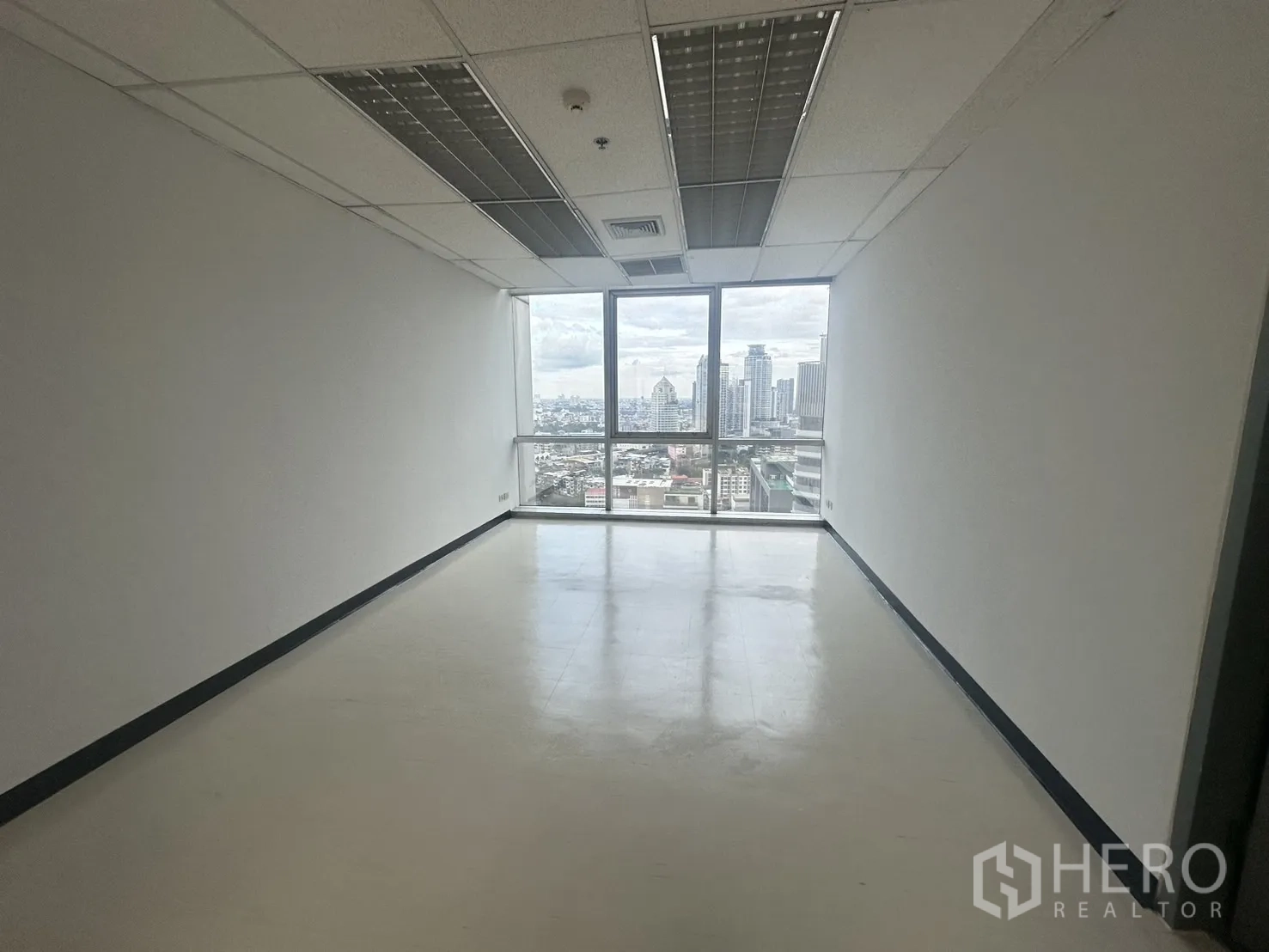 Office Space for rent - Private office room with a large window overlooking Bangkok’s skyline.