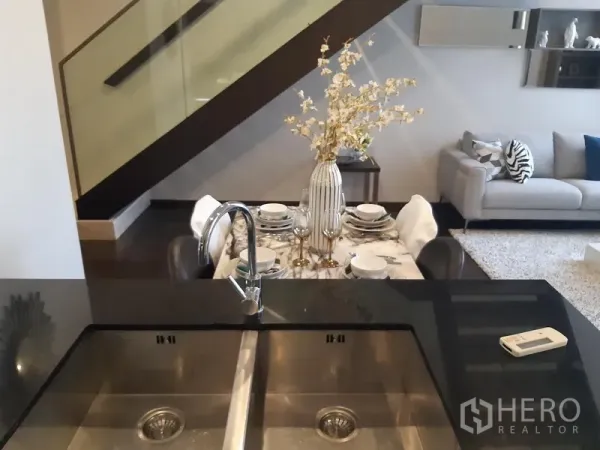 Condominium for rent in Watthana, Bangkok - View from the kitchen island with double sink toward the dining area and sofa.