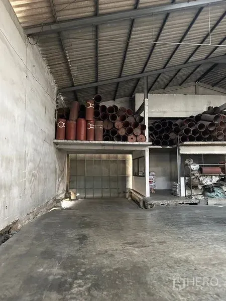 货栈 出租在Lat Krabang, Bangkok - 仓库内钢结构屋顶下的夹层平台，堆放大量管材。