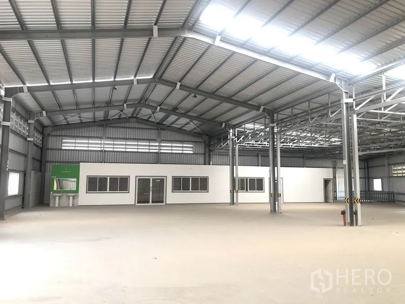 Warehouse for rent in Bang Yai, Nonthaburi - Warehouse bay with built‑in white office block, steel columns and bright roof panels.