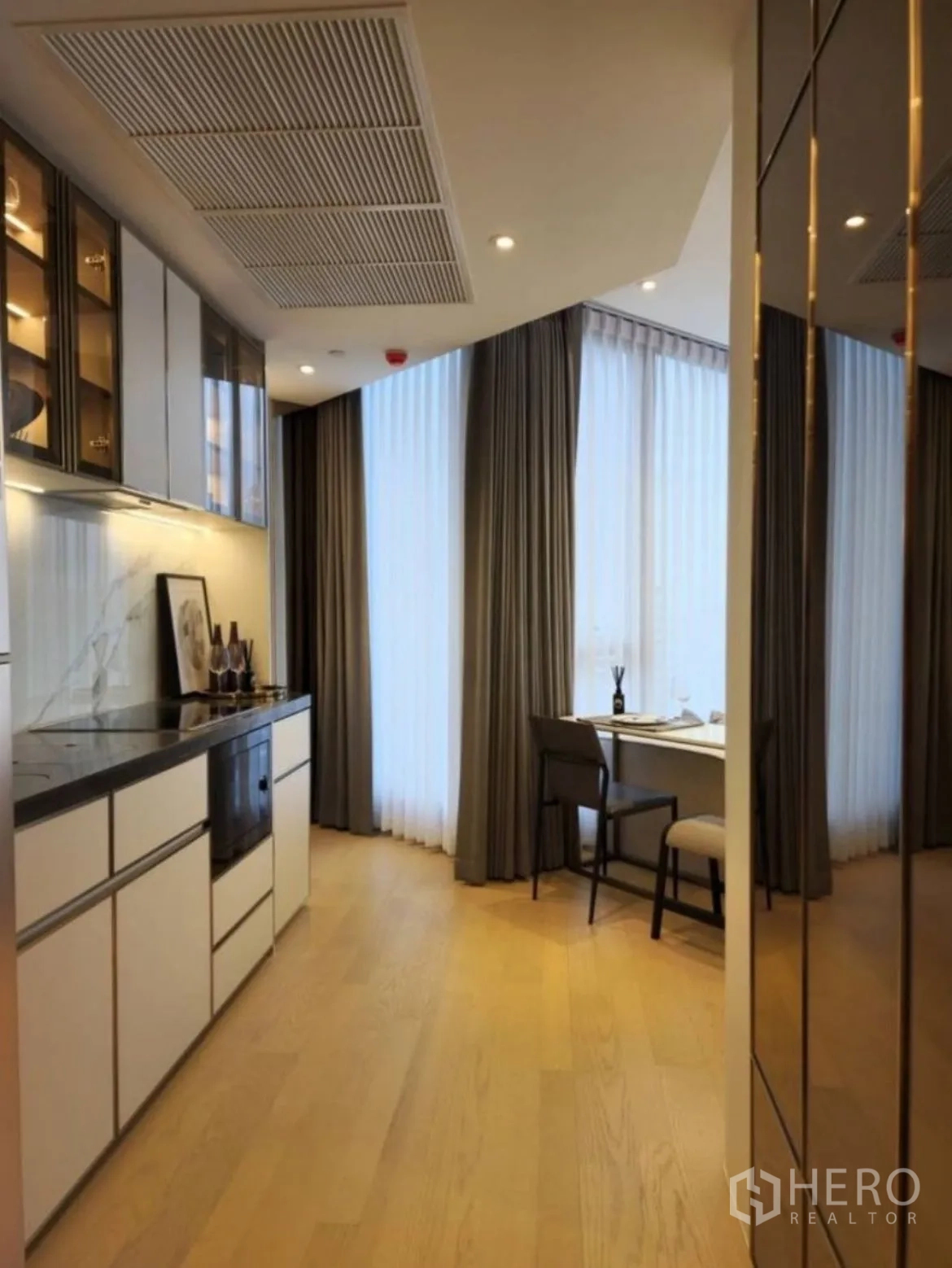 Condominium for rent in Din Daeng, Bangkok - Galley kitchenette with stone countertop and a window-side work desk.
