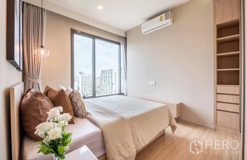 Condominium for rent in Chatuchak, Bangkok - Master bedroom showing built-in wardrobe, air conditioner and corner city views.
