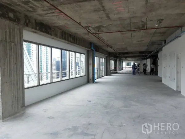 办公空间 出租在Watthana, Bangkok - 开放式毛坯办公区，长排窗户俯瞰城市建筑。