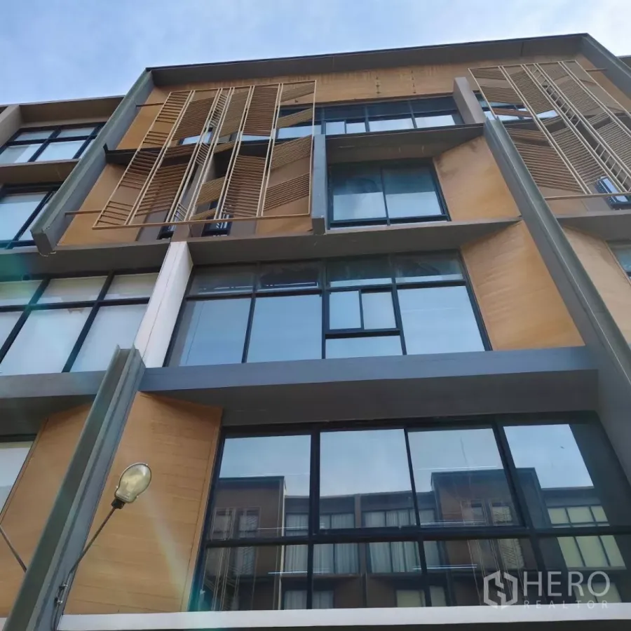 带办公室的家 出租或出售在Watthana, Bangkok - 多层家庭式办公楼外立面，大面积玻璃窗与木质百叶。