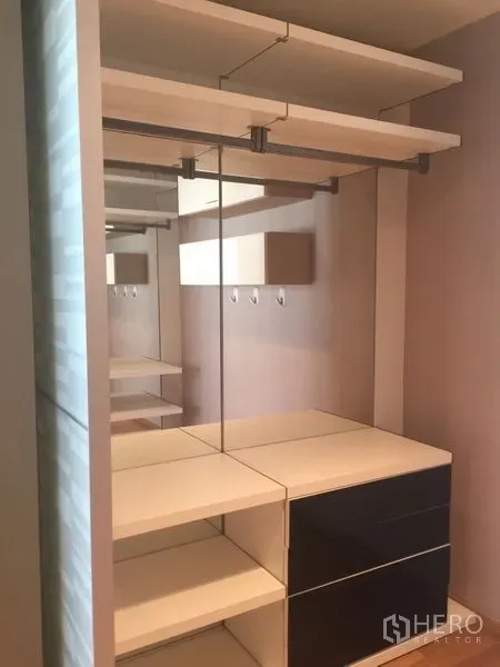 Condominium for rent - Walk-in closet with mirrors, shelves, and hanging rails in neutral tones.