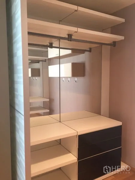 Condominium for rent - Walk-in closet with mirrors, shelves, and hanging rails in neutral tones.
