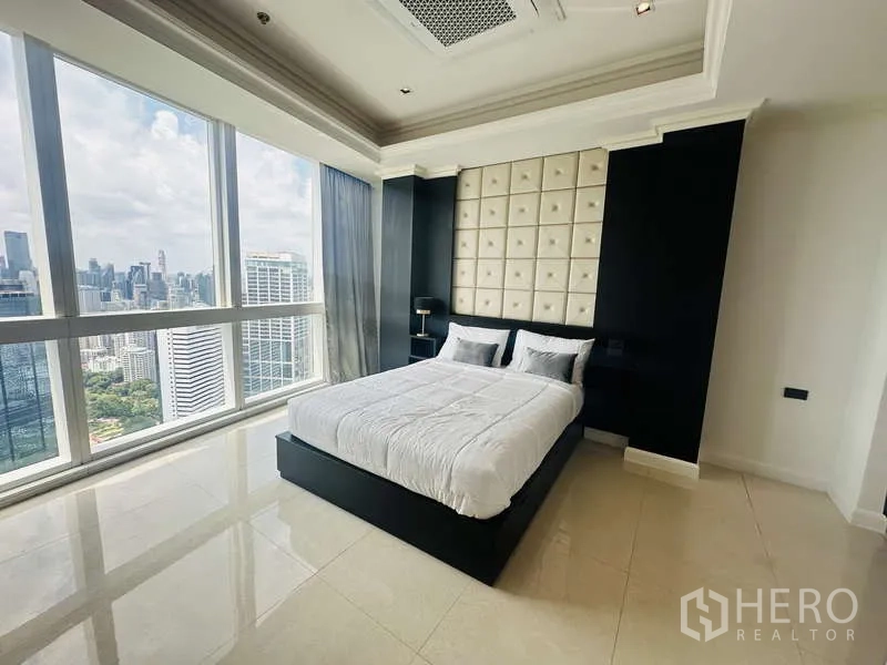 Condominium for rent or sale in Khlong Toei, Bangkok - Bedroom with floor-to-ceiling glass and sweeping views of Benjakitti Park and the city skyline.