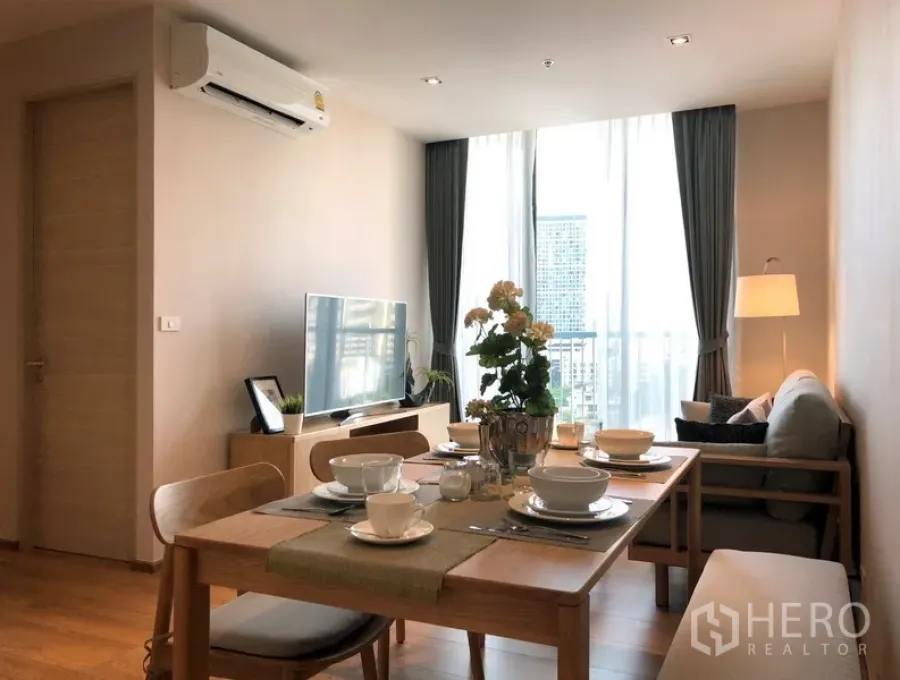 公寓 出售在Khlong Toei, Bangkok - 明亮的客餐厅一体空间，木质餐桌、沙发、电视柜与落地窗，享城市景观。