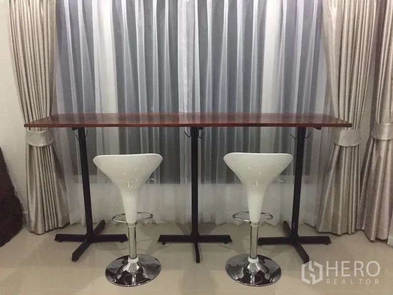 บ้าน ขายในPrawet, Bangkok - เคาน์เตอร์บาร์ไม้พร้อมสตูลสองตัวข้างหน้าต่างผ้าม่าน