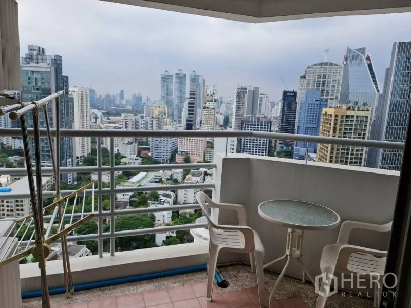 公寓 出租在Khlong Toei, Bangkok - 阳台配桌椅，眺望曼谷城市天际线。