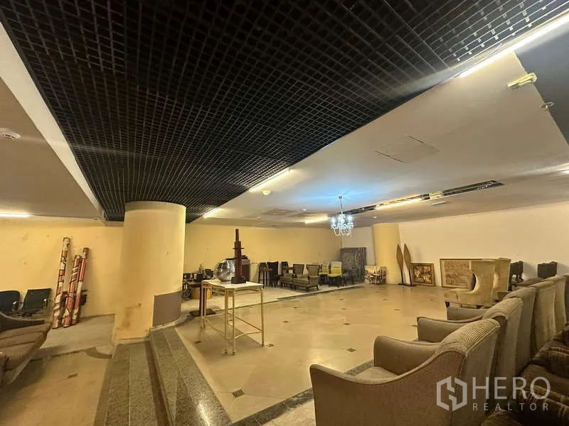 Retail Space for rent - Wide view of open showroom area with marble-style floors and feature lighting.