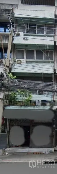 อาคารพาณิชย์ ขายในWatthana, Bangkok - ด้านหน้าตึกแถวหลายชั้นในกรุงเทพฯ พร้อมประตูม้วน ระเบียง และสายไฟริมถนน ใกล้ BTS เอกมัย.