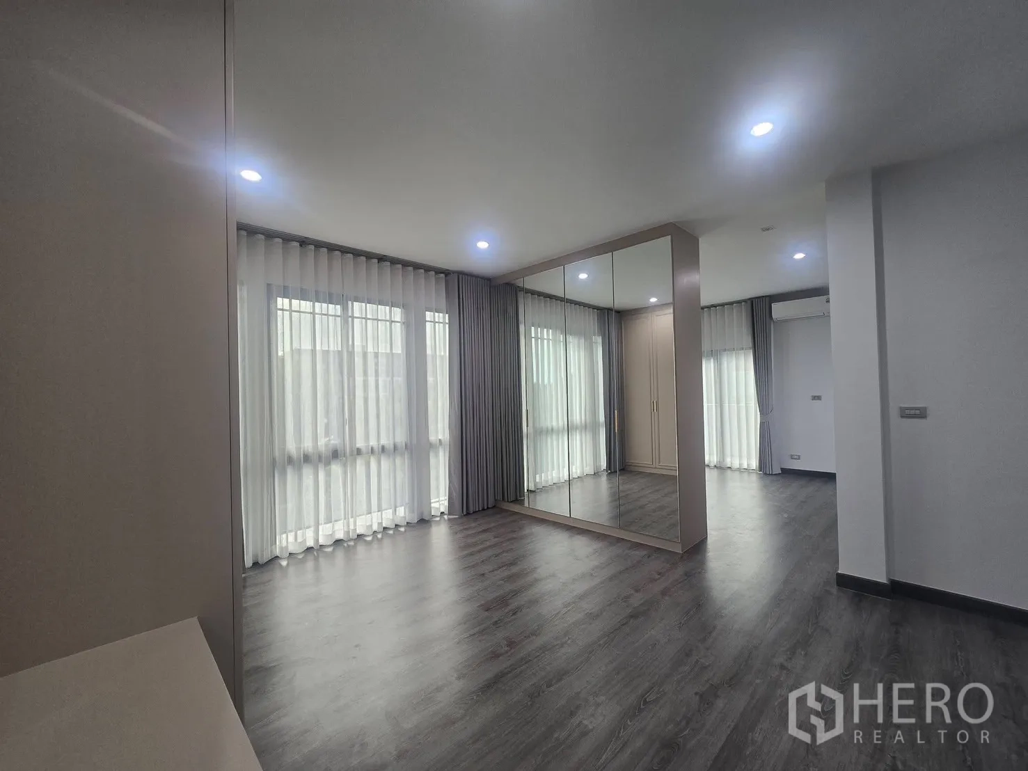 บ้านแฝด for rent in Suan Luang, Bangkok - พื้นที่ห้องนอนพร้อมตู้เสื้อผ้าบานกระจกเงา พื้นลายไม้ โคมไฟฝังฝ้า.