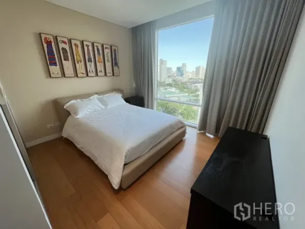 公寓 出租在Watthana, Bangkok - 明亮卧室，木地板、双人床，落地窗可观城市景观。
