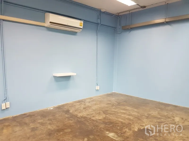 Home Office for sale in Khlong Toei, Bangkok - Blue-painted office room with AC and exposed wiring.