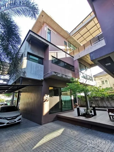带办公室的家 出售在Wang Thonglang, Bangkok - 多层现代家办外立面，带车棚、庭院与树木。
