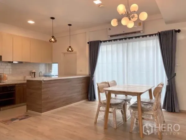 联排别墅 for rent in Prawet, Bangkok - 餐区靠近厨房，吊灯与大面积推拉玻璃门相连。