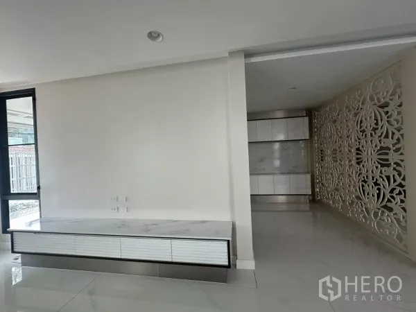 Townhouse for rent in Watthana, Bangkok - Minimal foyer featuring a marble TV console and ornate privacy screen.