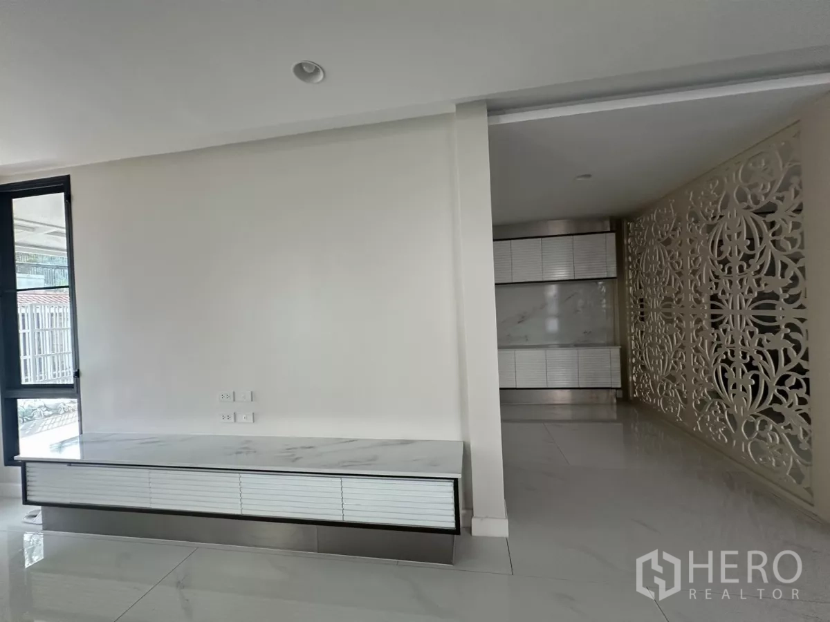Townhouse for rent in Watthana, Bangkok - Minimal foyer featuring a marble TV console and ornate privacy screen.