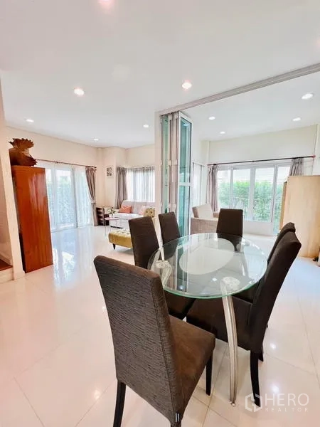 Detached House for rent - Open-plan dining area with glass-top table and upholstered chairs near windows.