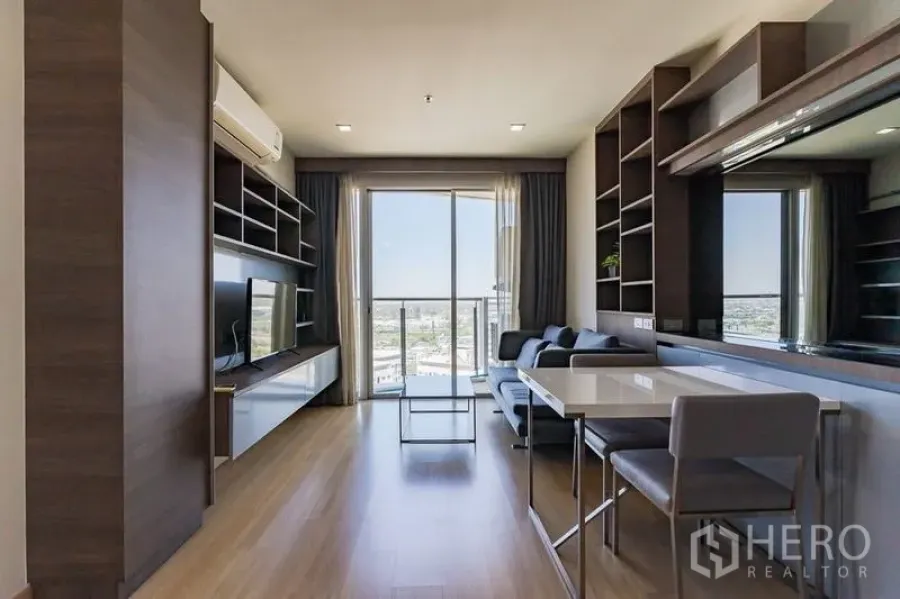 Condominium for rent - Living room toward balcony and skyline, with built-in storage and wood floors.