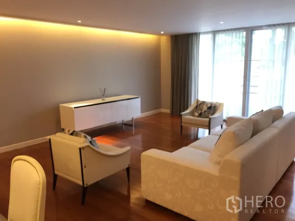 公寓 出租在Watthana, Bangkok - 宽敞客厅，沙发组合、边柜与落地窗采光充足。