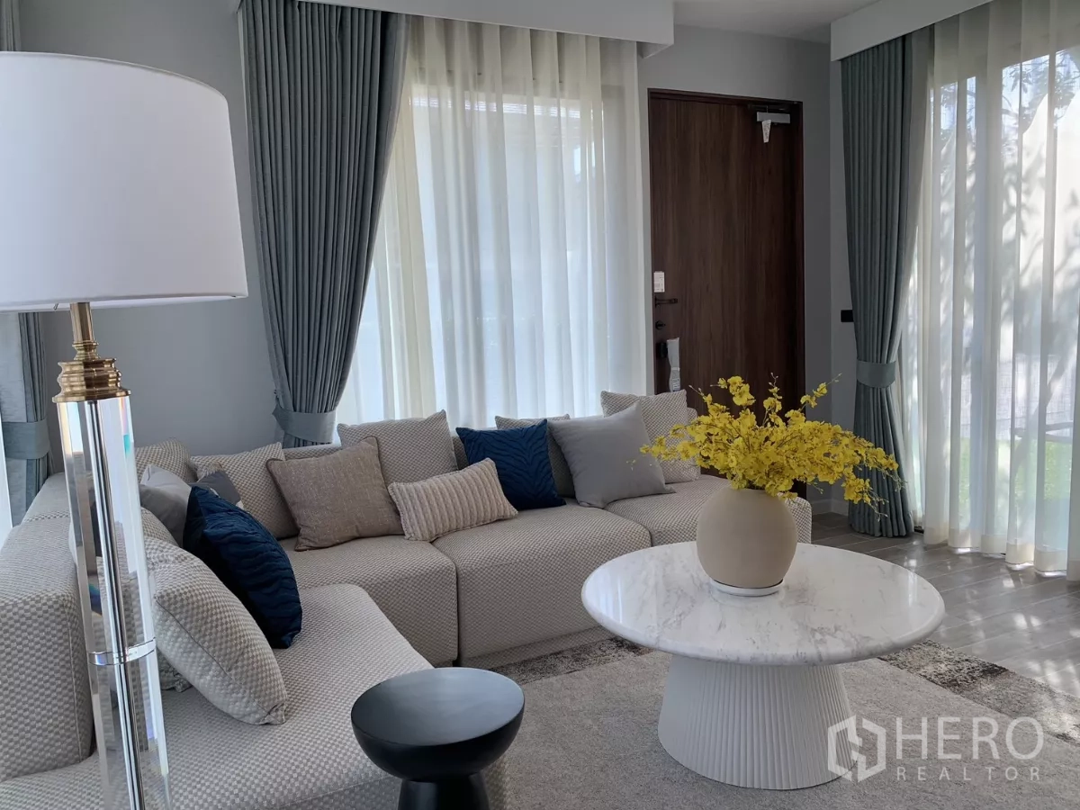 Detached House for rent in Bang Kapi, Bangkok - Bright living room in Hua Mak, Bang Kapi detached house with L‑shaped sofa, marble round table and sheer curtains.