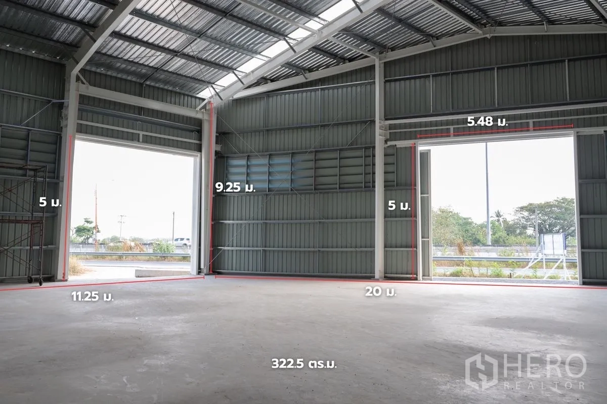 货栈 出租在Khlong Luang, Pathum Thani - 高挑仓库内部，宽大出入口，墙面标注尺寸。