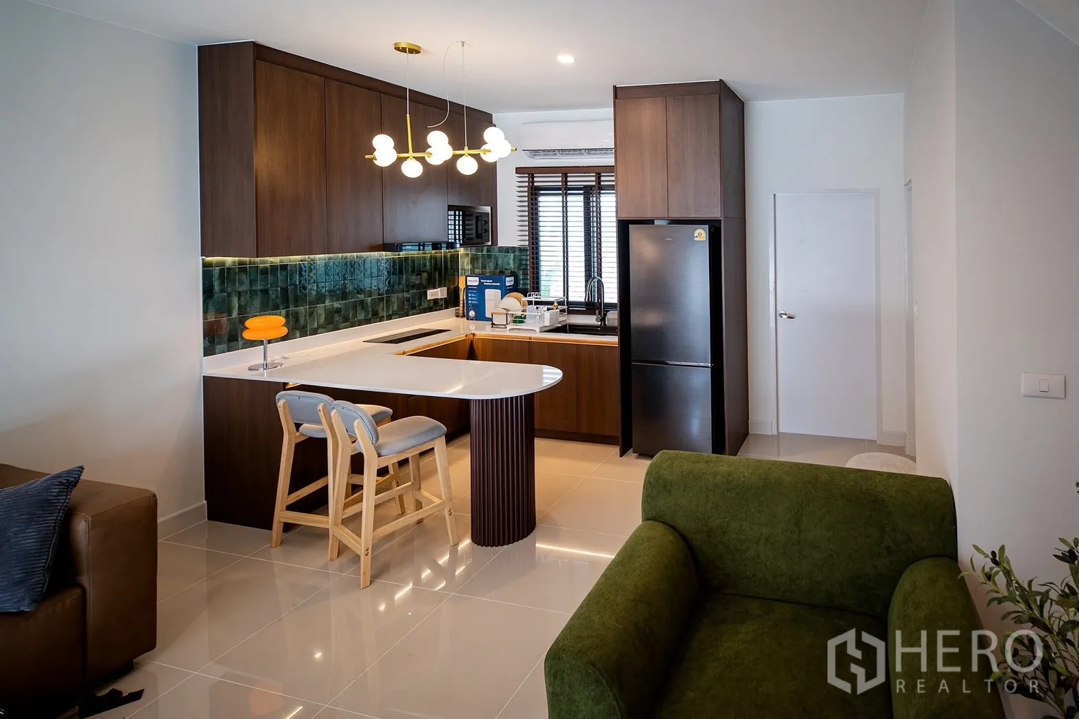 Townhouse for rent in Bang Phli, Samut Prakan - Kitchen with breakfast bar, pendant lighting and dark wood cabinetry.