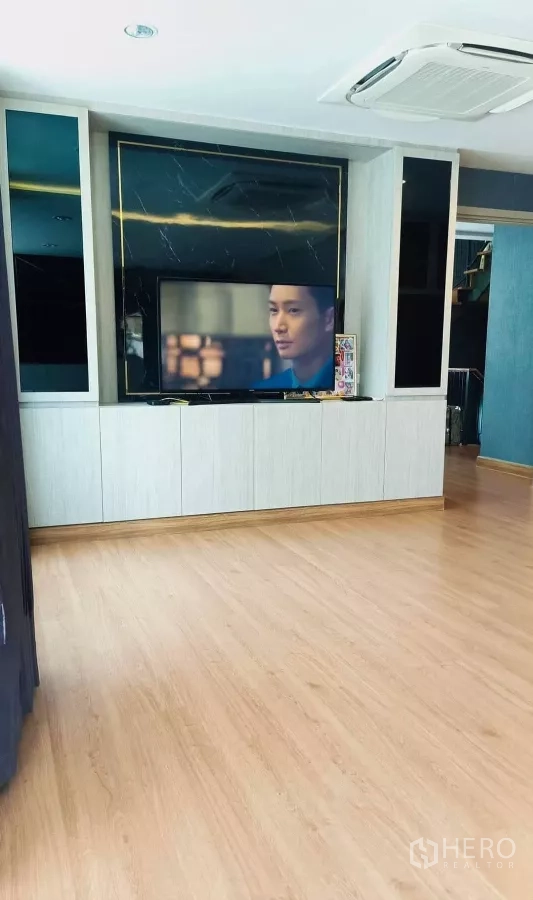 Detached House for rent or sale in Khan Na Yao, Bangkok - Spacious family room with built-in TV wall, wood flooring and cassette ceiling A/C.