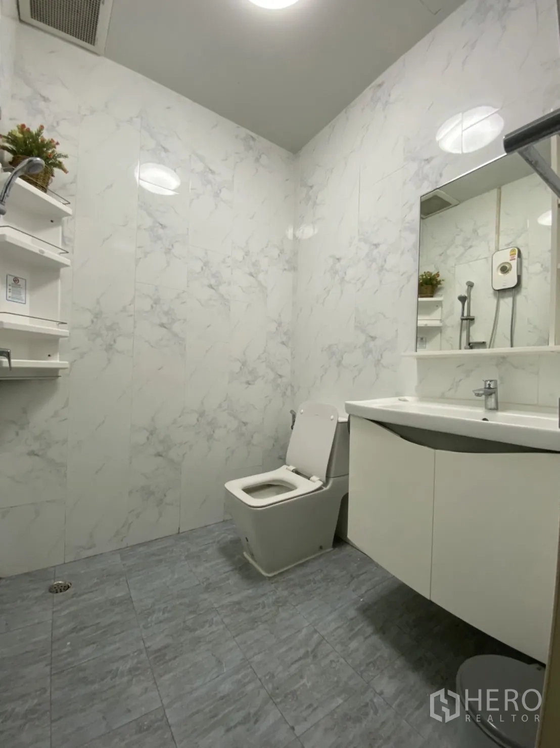 Townhouse for rent or sale - Modern bathroom with marble-look walls, shower and sleek vanity.