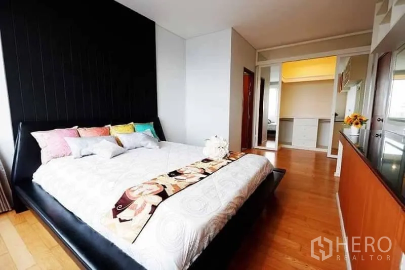 公寓 出租在Khlong San, Bangkok - 宽敞主卧，特大床、木地板与内置衣柜。