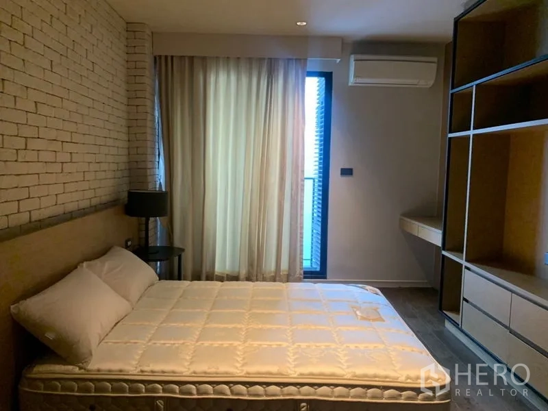 公寓 出租在Watthana, Bangkok - 明亮卧室，带内置书架、书桌与阳台门。